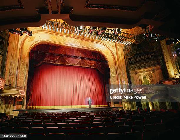 man standing on stage in empty theater - theatre stage stock pictures, royalty-free photos & images