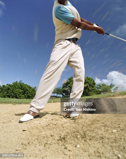 man swinging golf club in sand trap - beige pants stock-fotos und bilder