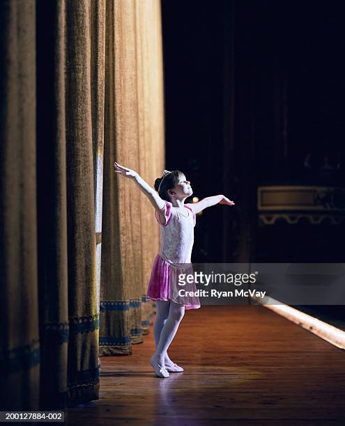 young ballerina (6-8) standing on stage with arms outstretched - theatrical performance imagens e fotografias de stock