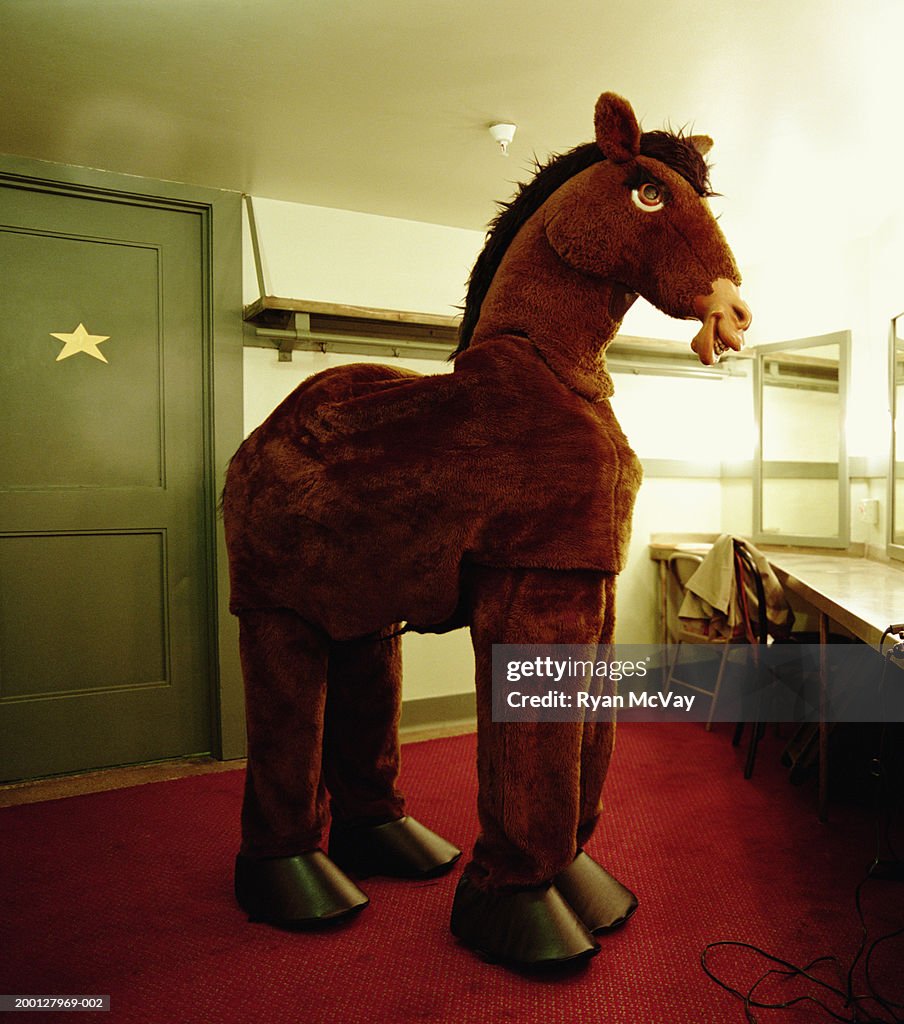 Two men wearing horse costume, waiting in dressing room