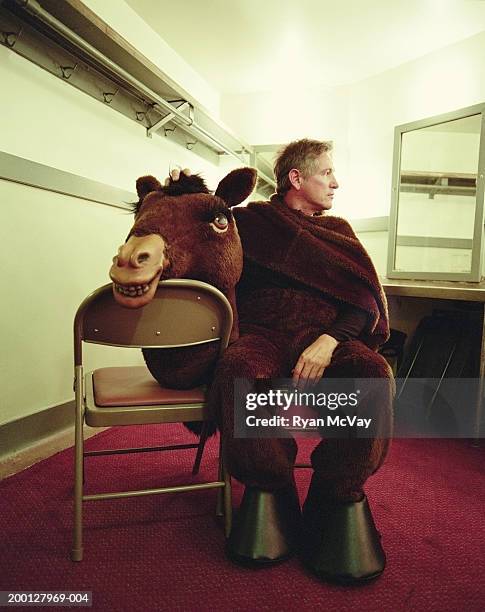 man wearing horse costume, sitting in dressing room - 馬の衣装 ストックフォトと画像