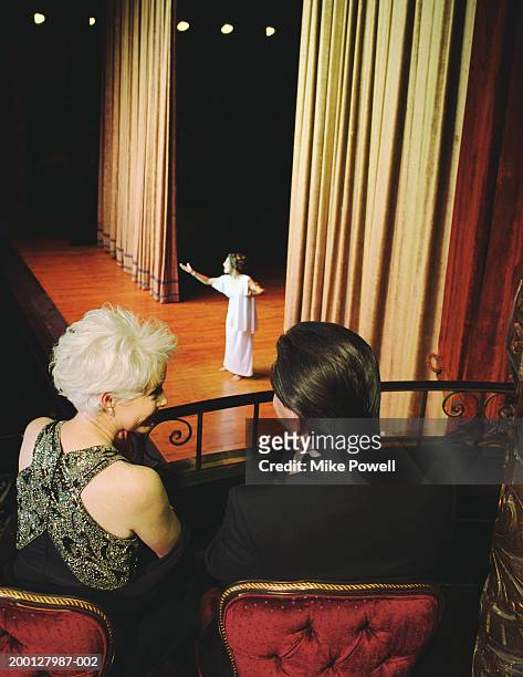 couple sitting in balcony seats at opera, rear view - opera theatre stockfoto's en -beelden