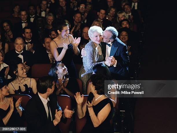 audience applauding mature woman, husband kissing cheek - awards ceremony stock pictures, royalty-free photos & images