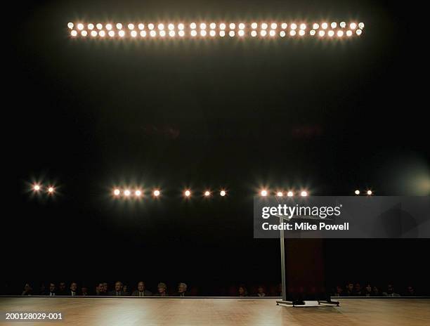 empty podium on stage, audience in background - auditorio fotografías e imágenes de stock