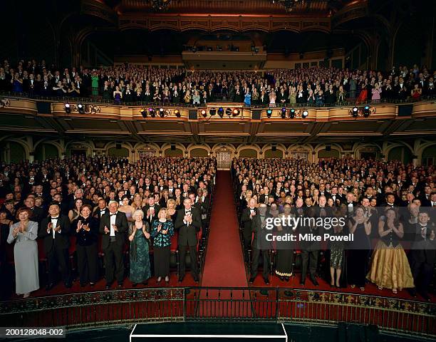 theater audience standing in formal attire, applauding - standing ovation photos et images de collection