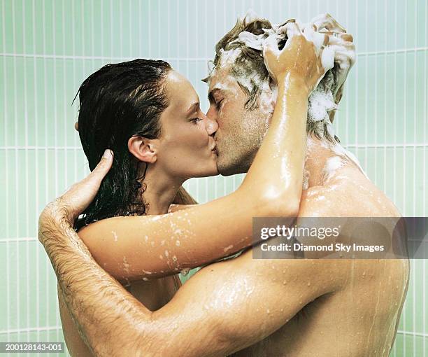 couple kissing in shower, woman shampooing man's hair - couples kissing shower stockfoto's en -beelden