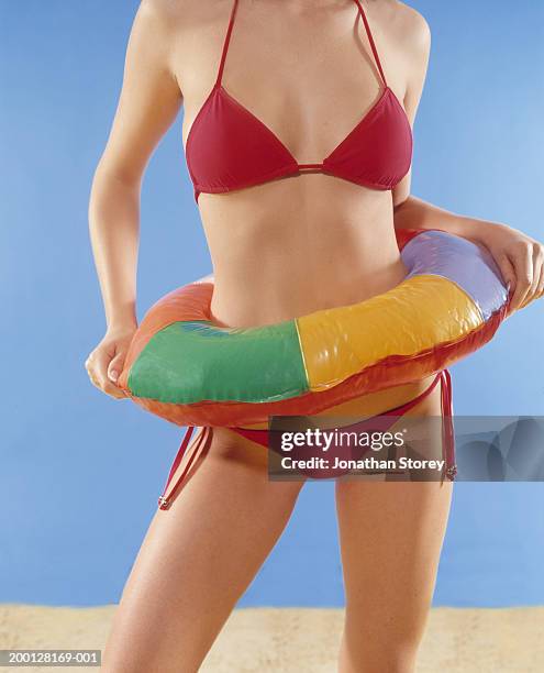 woman wearing bikini inside inflatable ring, mid section - travel2 stock pictures, royalty-free photos & images