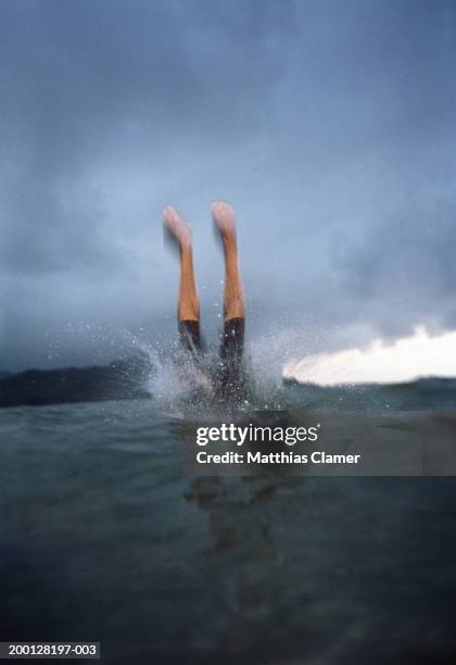 man diving into ocean (blurred motion, grainy) - den sprung wagen stock-fotos und bilder