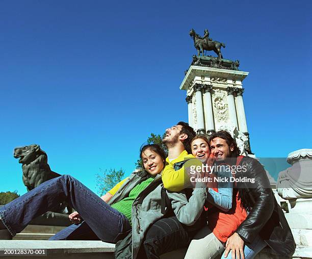 spain, madrid, retiro park, four friends at the alfonso xii monument - parque del buen retiro stock pictures, royalty-free photos & images