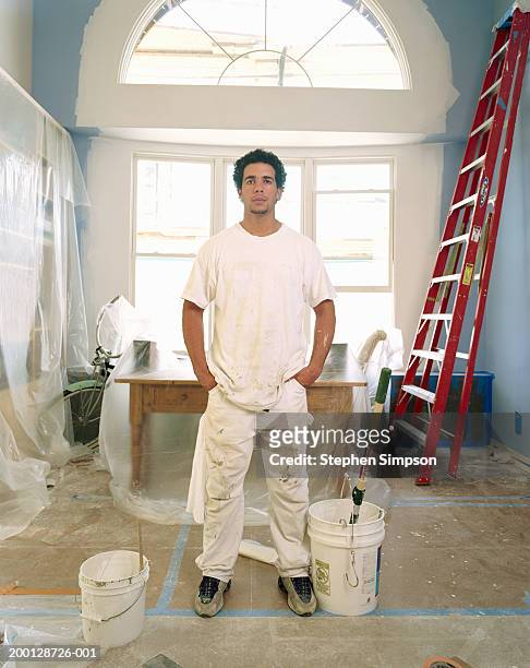 house painter in room covered protective tape and plastic, portrait - peintre photos et images de collection