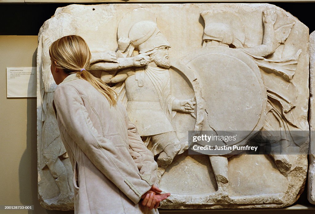 Woman reading sign next to museum exhibit