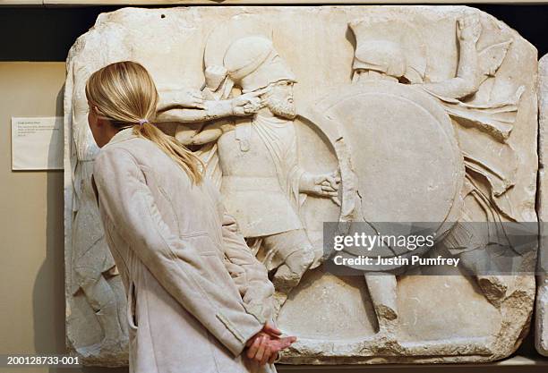 woman reading sign next to museum exhibit - british museum stock pictures, royalty-free photos & images