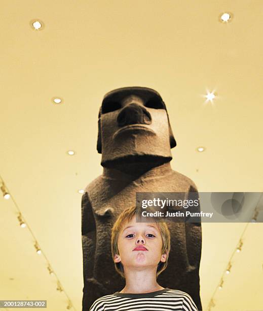 boy (7-9) mimicking expression on face of statue, portrait - travel2 stock pictures, royalty-free photos & images