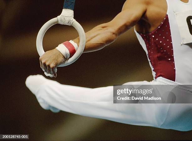 male gymnast performing on rings, close-up - ringen stock-fotos und bilder