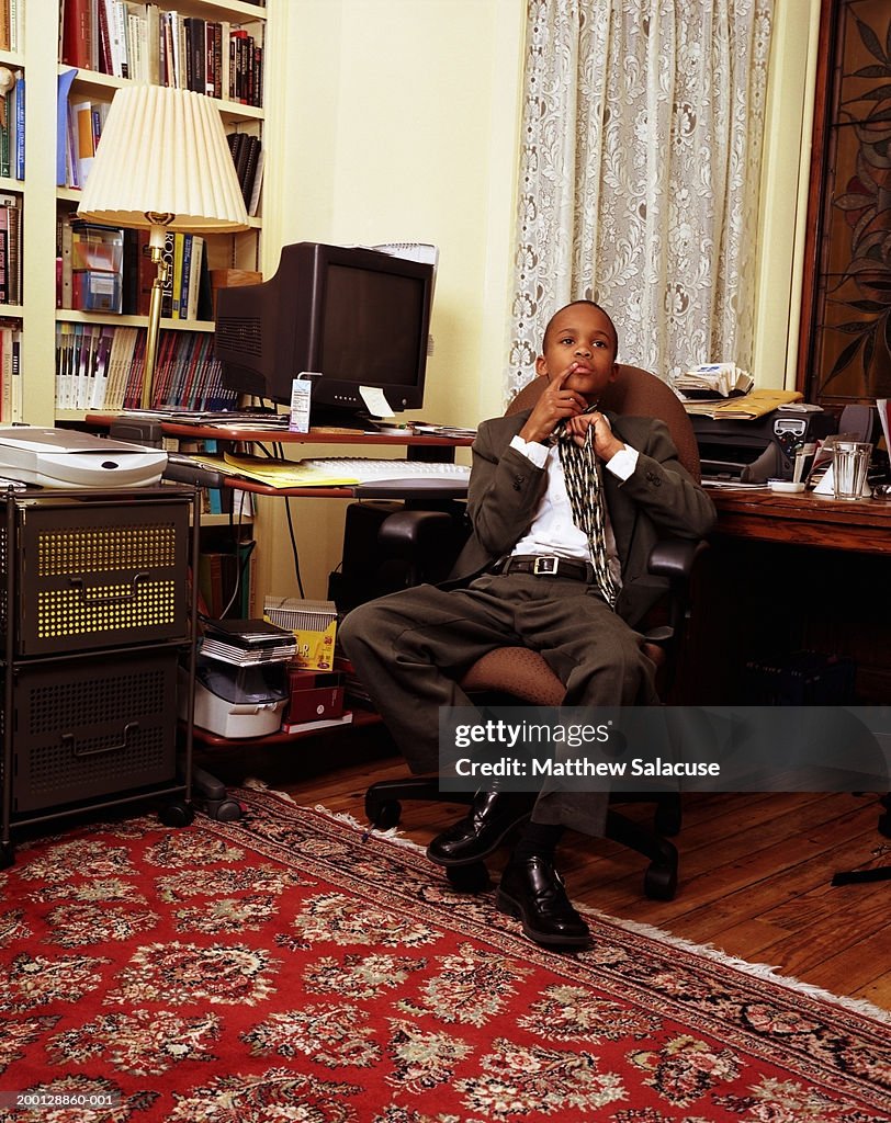 Boy (12-14) wearing suit, in home office