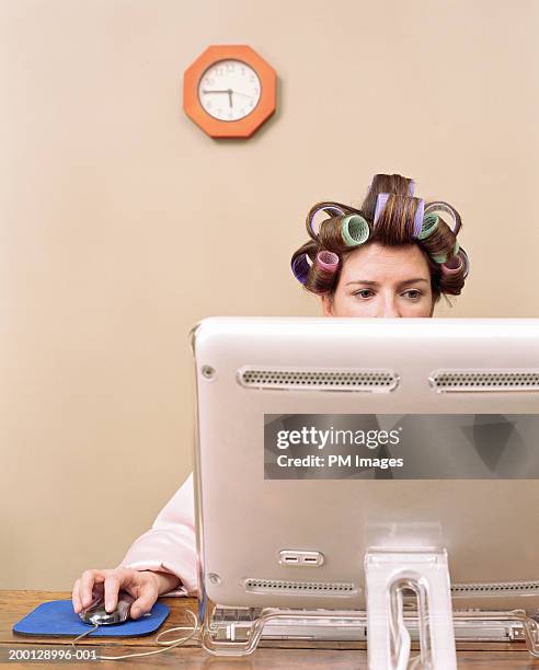 woman wearing hair rollers using computer in home office - hair curlers stock pictures, royalty-free photos & images