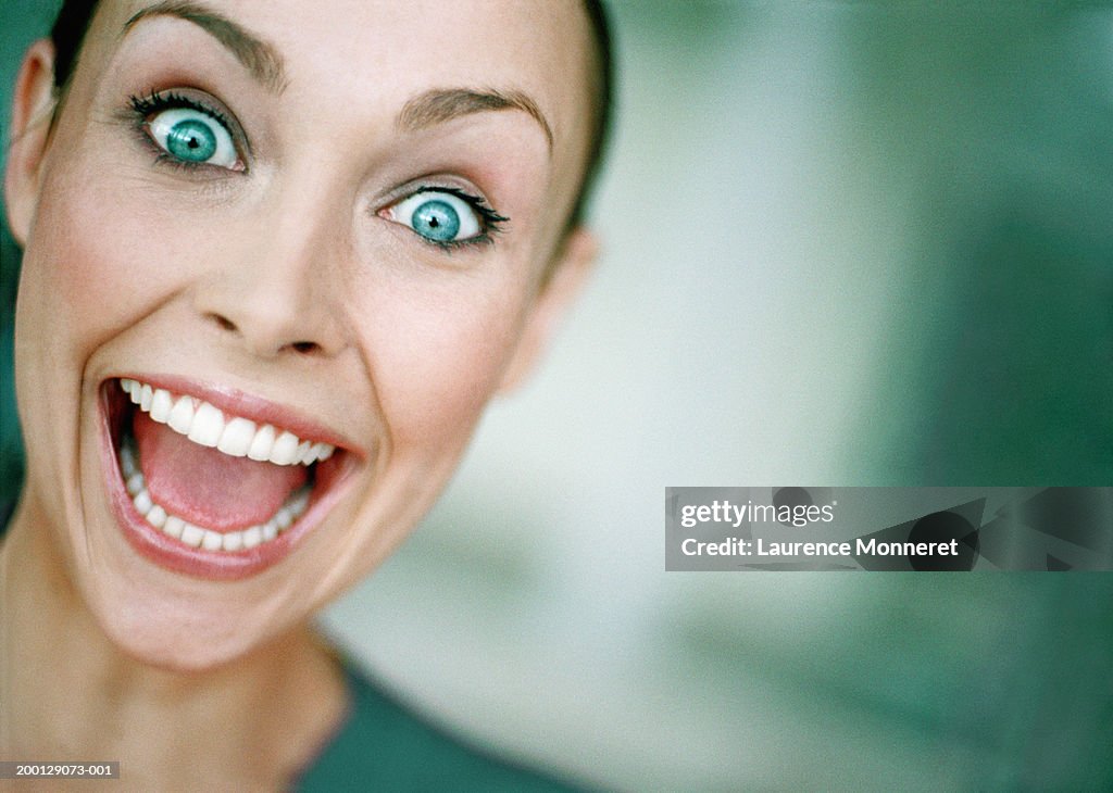 Young woman with eyes and mouth open wide, close-up, portrait