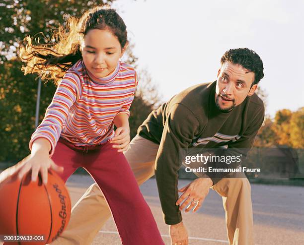 father and daughter (8-10) playing basketball - father emmanuel stock pictures, royalty-free photos & images