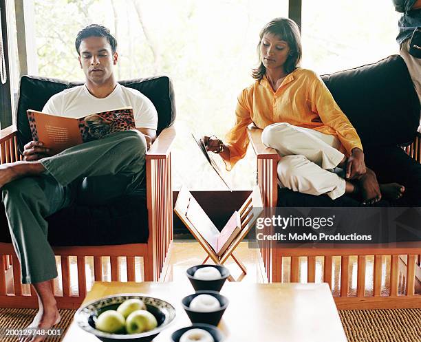 young couple reading in safari lodge - magazine retreat day 2 stock pictures, royalty-free photos & images