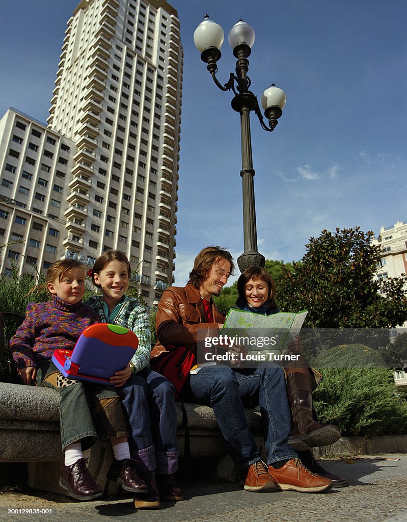 Family in park, parents looking at city map