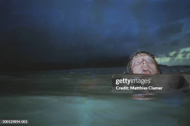 man showing fear, head barely above water - drowning stock pictures, royalty-free photos & images