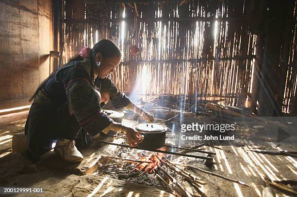 vietnam, han thao village, woman heating water pot - hot vietnamese women stock pictures, royalty-free photos & images