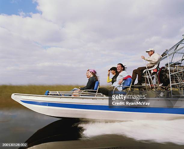 conductor y pasajeros en cuatro en bote aeronáutico, vista lateral - parque nacional everglades fotografías e imágenes de stock