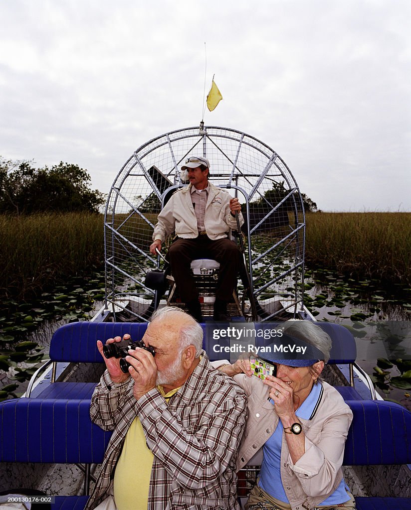 Couple Senior prendre des photos sur Bateau à hélice, chauffeur en arrière-plan