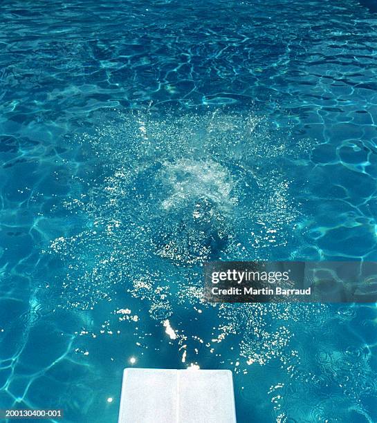 splash caused by girl (8-10) jumping in pool - jump in pool stock pictures, royalty-free photos & images