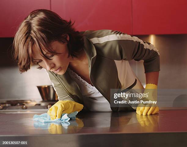young woman cleaning kitchen counter - obsessive stockfoto's en -beelden