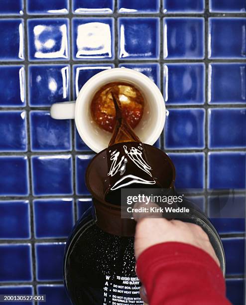 man pouring cup of coffee, overhead view - blau kachel stock-fotos und bilder