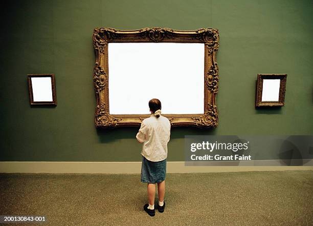 teenage girl (13-15) looking at empty frame in art gallery, rear view - museo fotografías e imágenes de stock