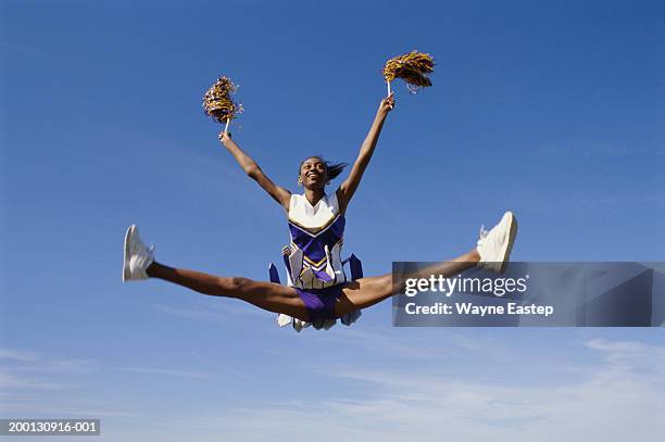teenage girl cheerleader (16-18) leaping - ragazza pon pon foto e immagini stock
