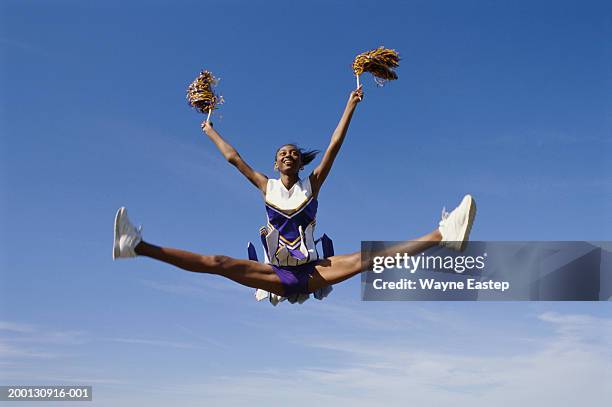 teenage girl cheerleader (16-18) leaping - cheerleader photos stock pictures, royalty-free photos & images