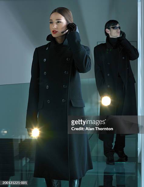 man and woman using communication device, holding illuminated torches - mann headset stock-fotos und bilder