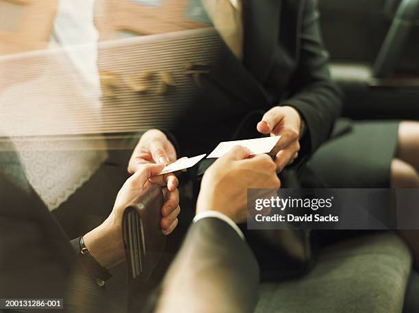 businessman and woman exchanging business cards, close up - biglietto da visita foto e immagini stock