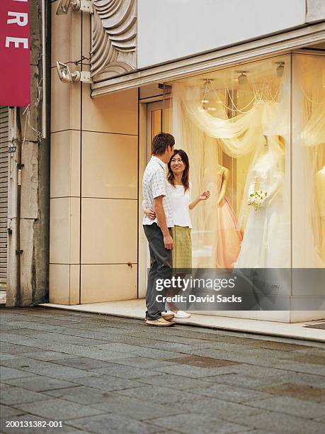 couple talking in front of bridal shop - wedding dress stock pictures, royalty-free photos & images