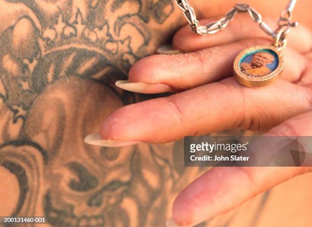 man holding pendant with buddhist icon against chest, close-up - pendant bildbanksfoton och bilder