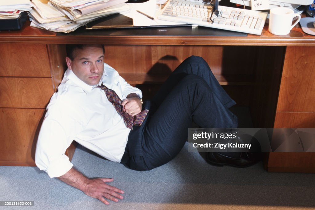 Businessman Underneath Desk High Res Stock Photo Getty Images businessman-underneath-desk-high-res-stock-photo-getty-images