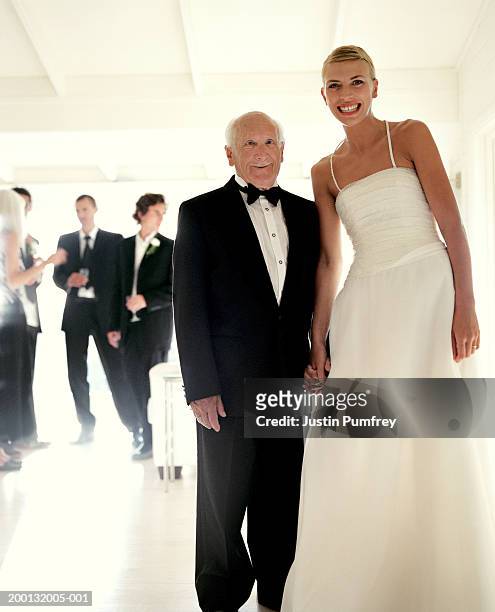 senior man holding hands with young bride, portrait - old man young woman stockfoto's en -beelden