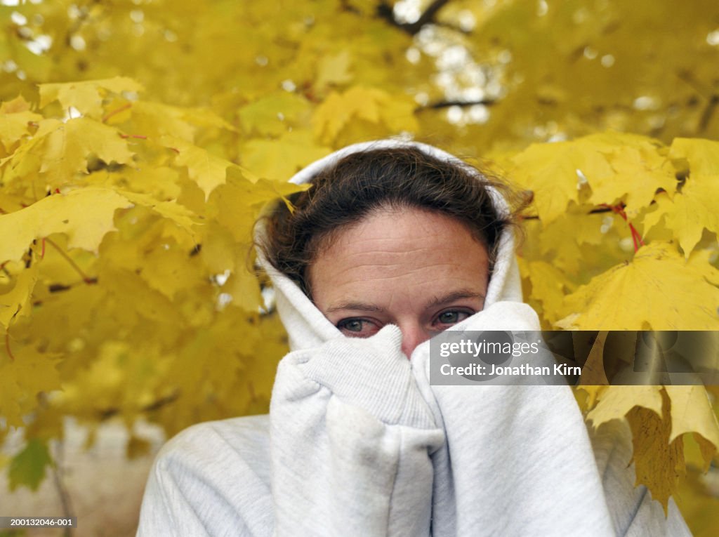 Woman wearing hooded sweatshirt, closeup, autumn