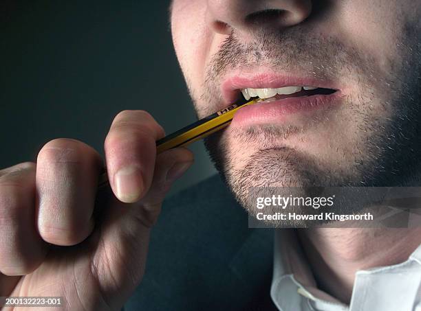 man biting end of pencil, close-up - man open mouth stock pictures, royalty-free photos & images