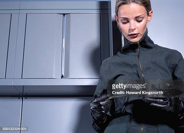 young woman holding spanner in gloved hands, low angle view - leather glove ストックフォトと画像