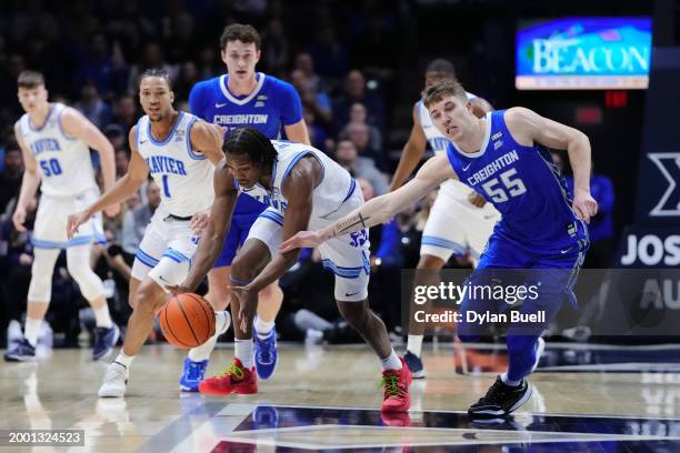 Quincy Olivari of the Xavier Musketeers and Baylor Scheierman of the Creighton Blue Jays chase after a loose ball at the Cintas Center on February...