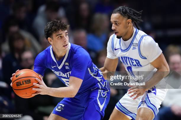Francisco Farabello of the Creighton Blue Jays handles the ball while being guarded by Trey Green of the Xavier Musketeers in the first half at the...