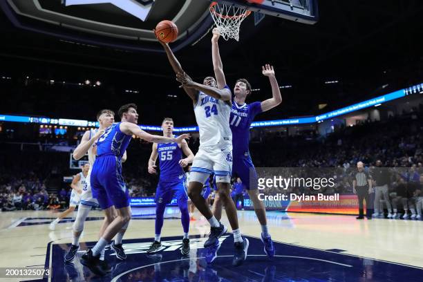 Abou Ousmane of the Xavier Musketeers attempts a shot while being guarded by Ryan Kalkbrenner of the Creighton Blue Jays in the first half at the...