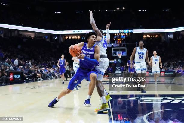 Trey Alexander of the Creighton Blue Jays dribbles the ball while being guarded by Dayvion McKnight of the Xavier Musketeers in the second half at...