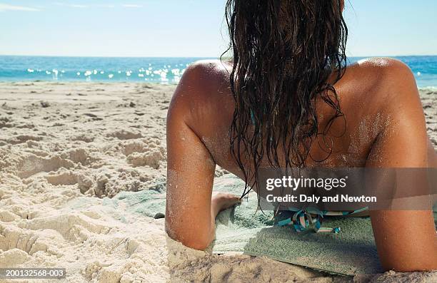 woman leaning back on elbows on beach, rear view, close-up - auf rücken liegen stock-fotos und bilder