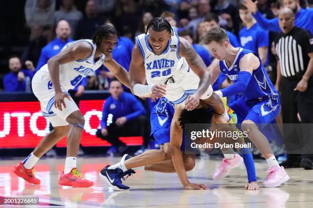 Dayvion McKnight of the Xavier Musketeers and Trey Alexander of the Creighton Blue Jays dive after a loose ball in the second half at the Cintas...