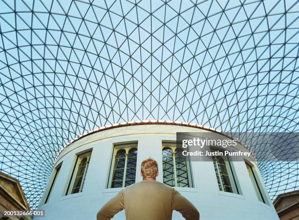 man standing under glass roof, arms akimbo, low angle view - british museum photos et images de collection